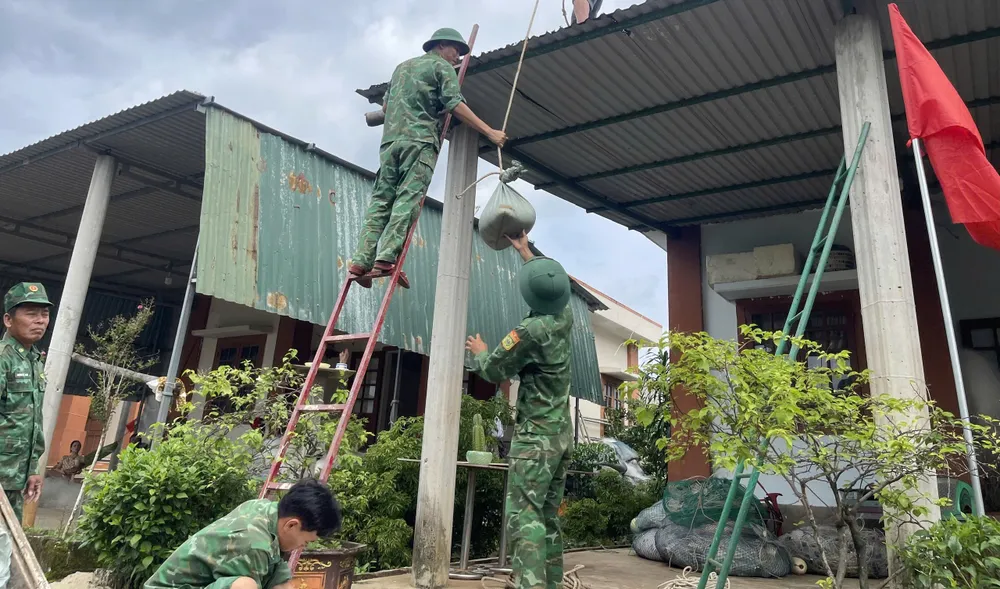 Lực lượng chức năng hỗ trợ người dân giằng chống nhà cửa. bão số 6