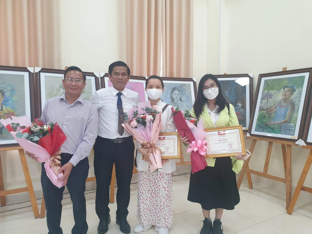 Hoạ sĩ Lê Sa Long (giữa-bên trái) bên cạnh sáng tác của mình cùng bạn bè tại Hội nghị tiếp nhận hiện vật. Ảnh: VĂN HÀ.