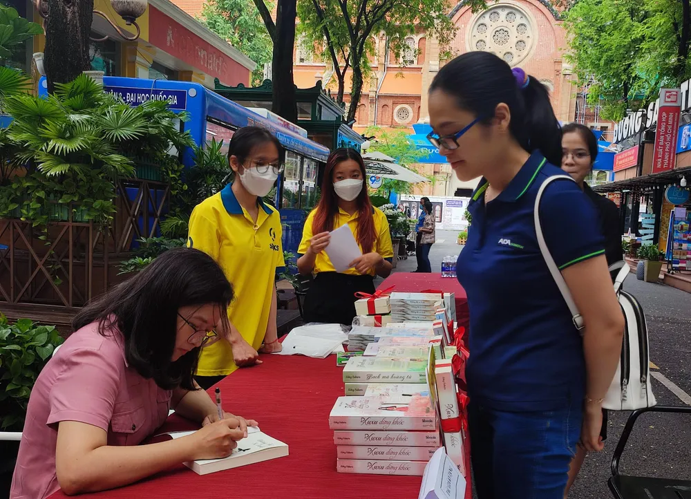 Nữ tác giả ký sách cho bạn đọc. Ảnh: BTC. Nữ tác giả ký sách cho bạn đọc. Ảnh: BTC.