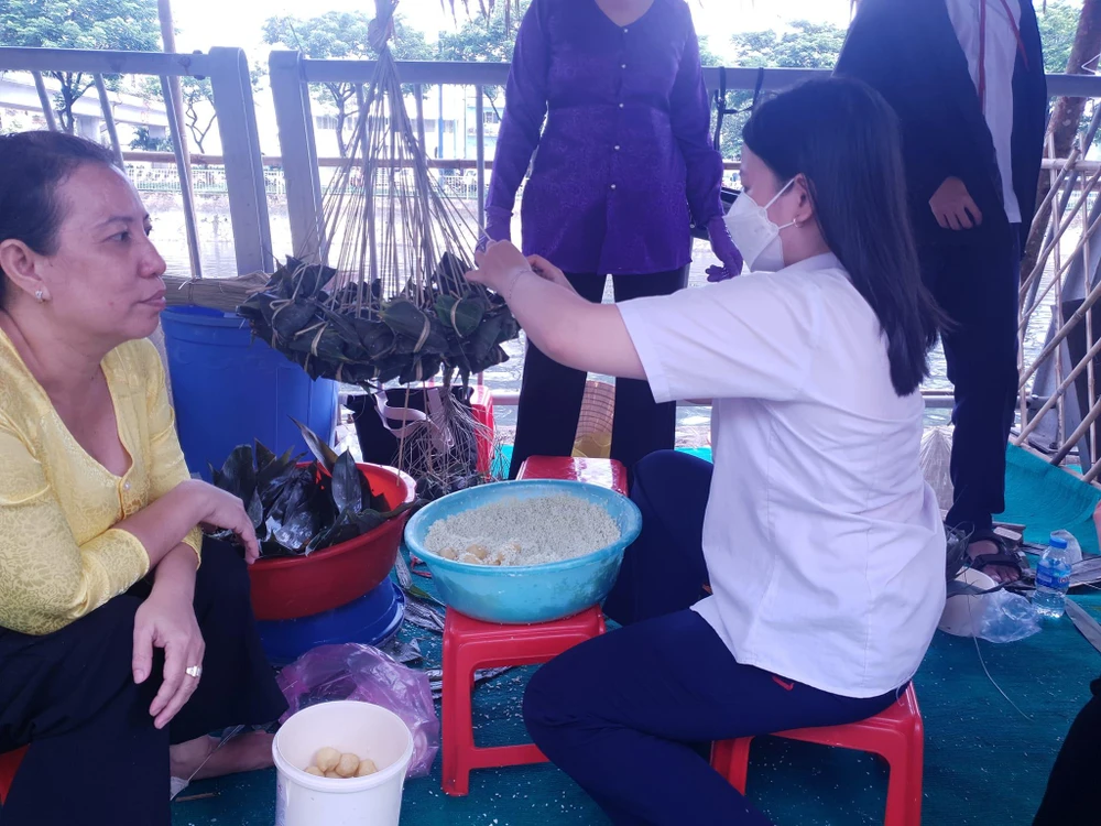 Con gái chị Hà cũng cũng tham gia gói bánh cùng mẹ sau khi tan học về. Ảnh: VĂN HÀ.