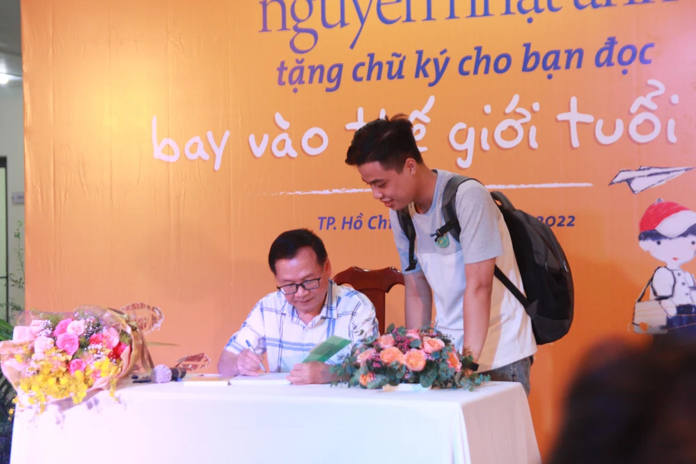 Nhà văn Nguyễn Nhật Ánh tặng chữ ký cho các bạn đọc. Ảnh: BTC.