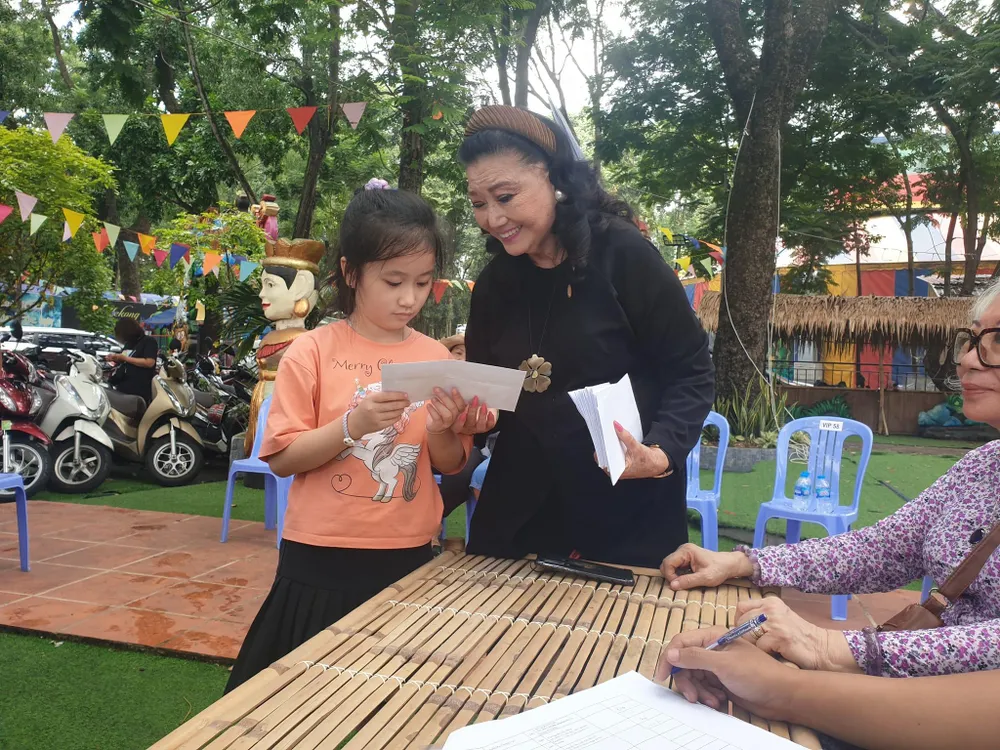 NSND Kim Cương trao tiền hỗ trợ cho các bé. Ảnh: VĂN HÀ.