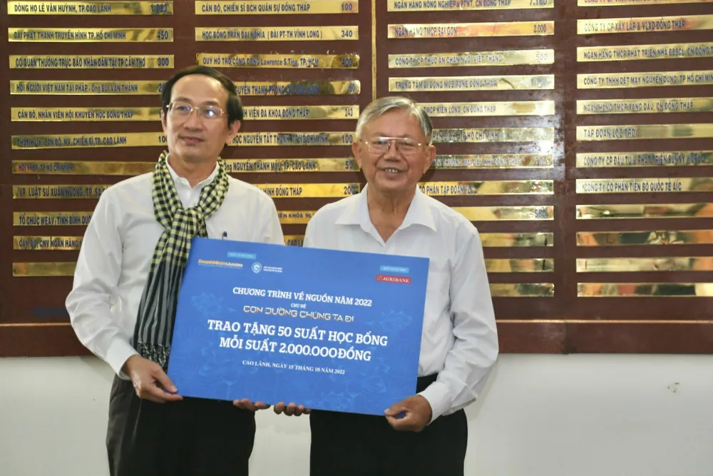 Ông Trần Hoàng, TBT Tạp chí Doanh nhân Sài Gòn trao 50 suất học bổng, trị giá 100 triệu đồng cho ông Võ Hồng Nhân. Ảnh: CTCC