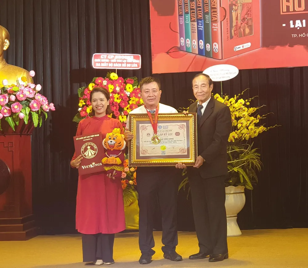 Nhà văn Lại Văn Long nhận huy chương và chứng nhận kỷ lục của tổ chức Kỷ lục Việt Nam. Ảnh: HÀ NGUYỄN