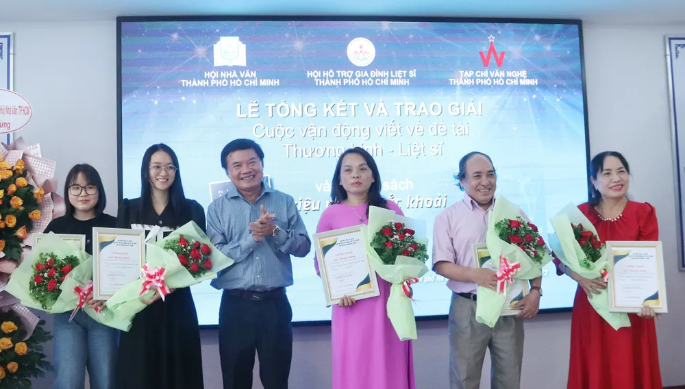 Nhà văn Bùi Anh Tấn trao giải khuyến khích cho các tác giả. Ảnh: HÀ NGUYỄN