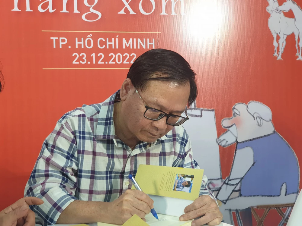 Nhà văn ký tặng sách cho bạn đọc. Ảnh: VĂN HÀ