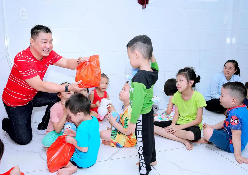 Tài tử Lý Hùng tặng quà cho các trẻ mồ côi tại mái ấm "Tình mẹ". Ảnh: NSCC Tài tử Lý Hùng tặng quà cho các trẻ mồ côi tại mái ấm "Tình mẹ". Ảnh: NSCC