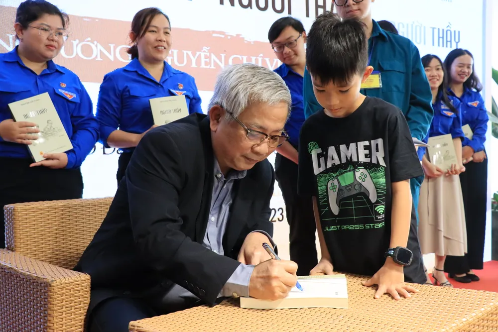 Thượng tướng, GS.TS Nguyễn Chí Vịnh ký tặng sách cho độc giả nhí. Ảnh: HÀ NGUYỄN