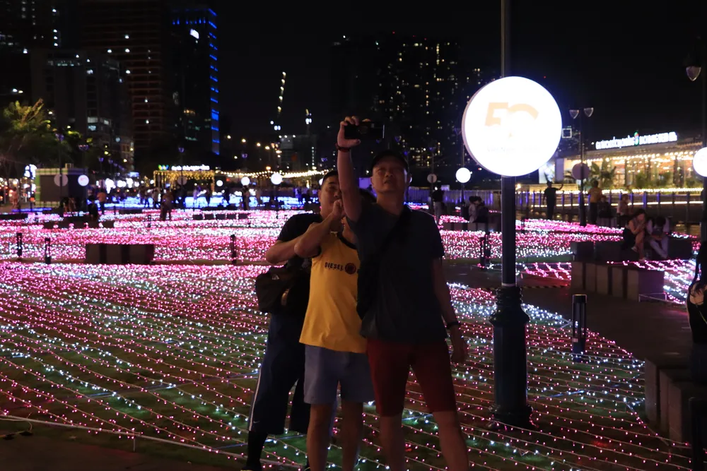 Du khách hào hứng chụp ảnh cùng với dàn đèn LED &quot;khủng&quot;. Ảnh: HÀ NGUYỄN