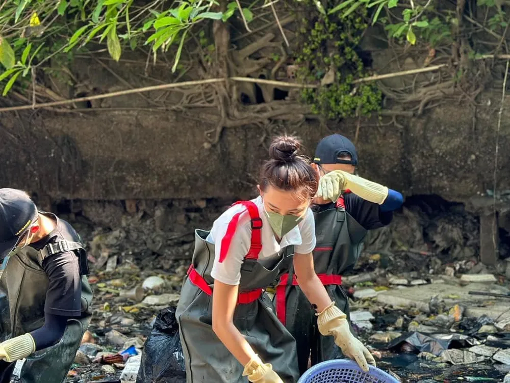 Người đẹp sinh năm 1998 tất bật cùng mọi người dọn rác. Ảnh: FBNV