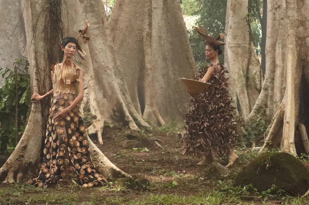 Từ phải sang: Á hậu H&apos;Ăng Niê diện thiết kế làm từ hoa chò nâu và người mẫu Trang Phạm diện thiết kế từ lá cây khô. Ảnh: HÀ NGUYỄN