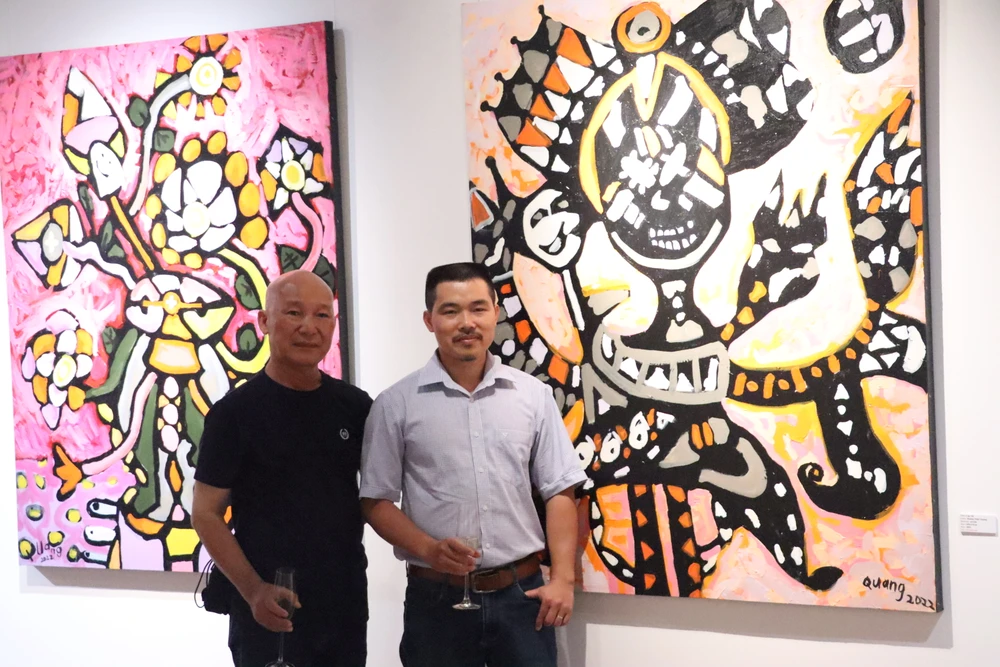 Họa sĩ Hoàng Văn Điểm (phải) cùng họa sĩ Ngô Đồng tại triển lãm