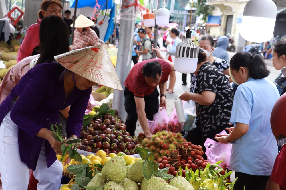 Người dân đến tham quan và mua sắm, thưởng thức những loại trái cây được bày bán.