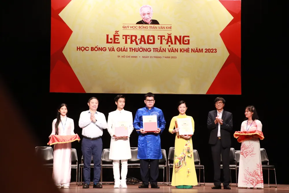 Ông Dương Anh Đức, Phó Chủ tịch UBND TP.HCM trao học bổng cho Trịnh Nhật Minh (áo dài trắng) và các học sinh, sinh viên.