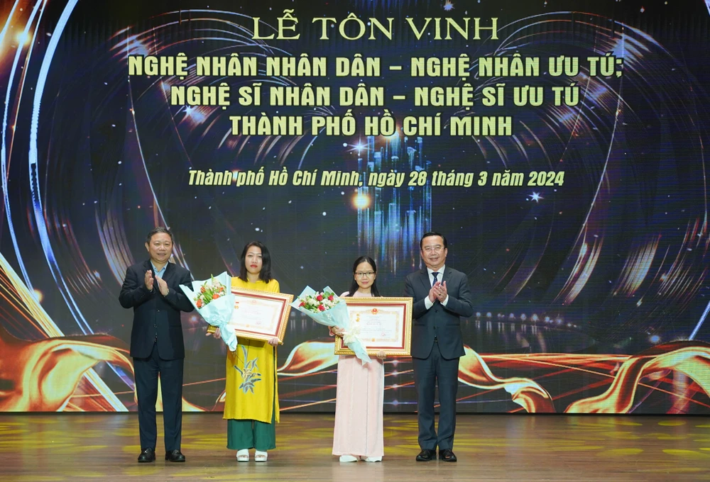 Ông Dương Anh Đức, Phó Chủ tịch UBND TP.HCM cùng ông Trần Thế Thuận, GĐ Sở VH&TT TP.HCM thực hiện nghi thức truy tặng danh hiệu NSND, NSƯT là (đại diện gia đình) NSND Lê Trí Tưởng và NSƯT Lê Văn Tĩnh. truy tang.jpg