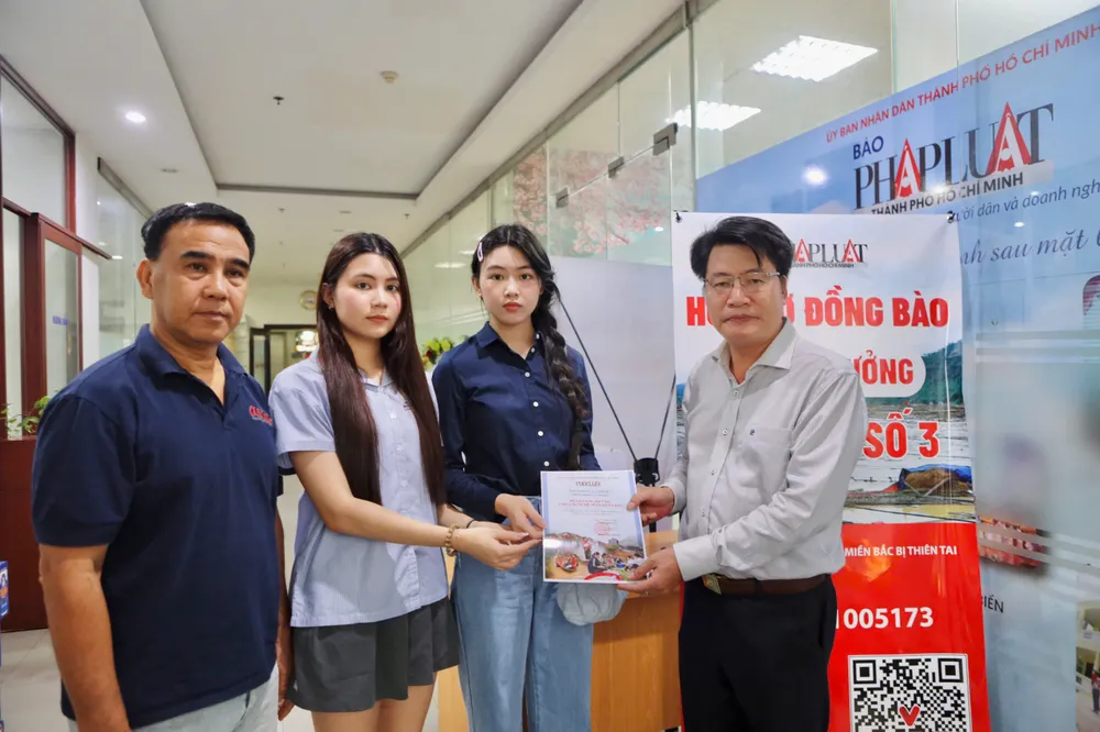 Ông Đinh Đức Thọ, Phó Tổng biên tập Báo Pháp Luật TP.HCM trao thư cảm ơn cho hai con gái của nghệ sĩ Quyền Linh. Ảnh: NGUYỆT NHI nghe-si-quyen-linh.jpg