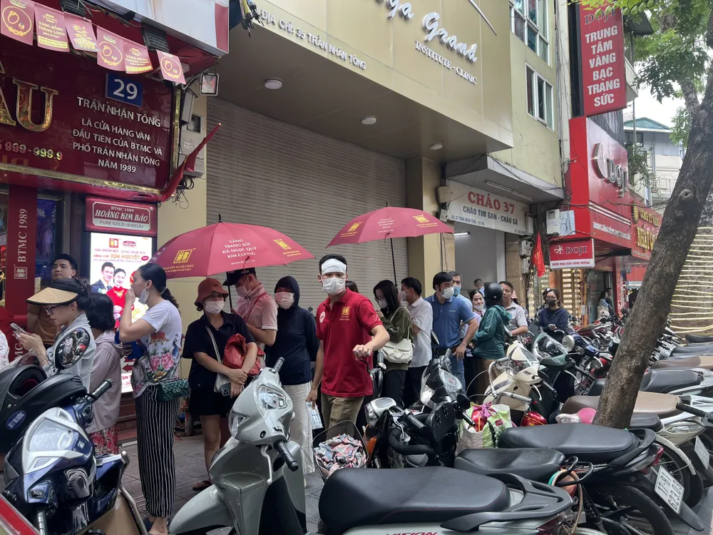 Người dân che ô xếp hàng 2 tiếng để mua vàng dưới trời nắng gắt - Ảnh: Ngọc Diệp Từ chuyện thị trường hết vàng nhẫn đến hướng chấm dứt bất cập trên thị trường vàng trong nước