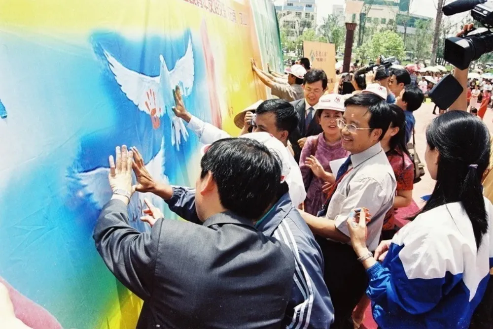 Đại biểu thanh niên Việt-Trung tham gia “in dấu tay”, biểu thị tình đoàn kết, hữu nghị tại Lễ hội văn hoá dân tộc thanh niên châu Văn Sơn, tỉnh Vân Nam (Trung Quốc), ngày 13-6-2004. (Ảnh: TTXVN) 1608B.jpg