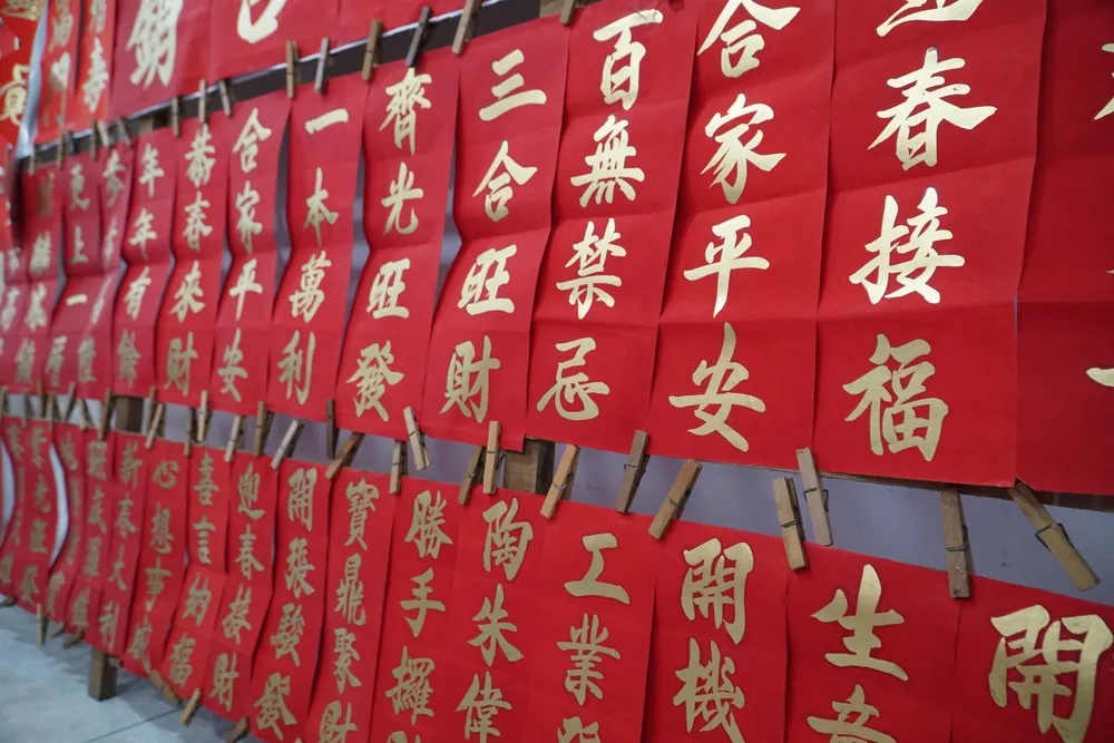 Tục treo liễn là một truyền thống lâu đời của người Hoa trong ngày Tết, thể hiện những ước vọng cho một năm mới tốt đẹp và may mắn. Hàng loạt lời hay, ý đẹp sẽ được thể hiện qua nét bút nhũ vàng trên nền giấy hồng điều.