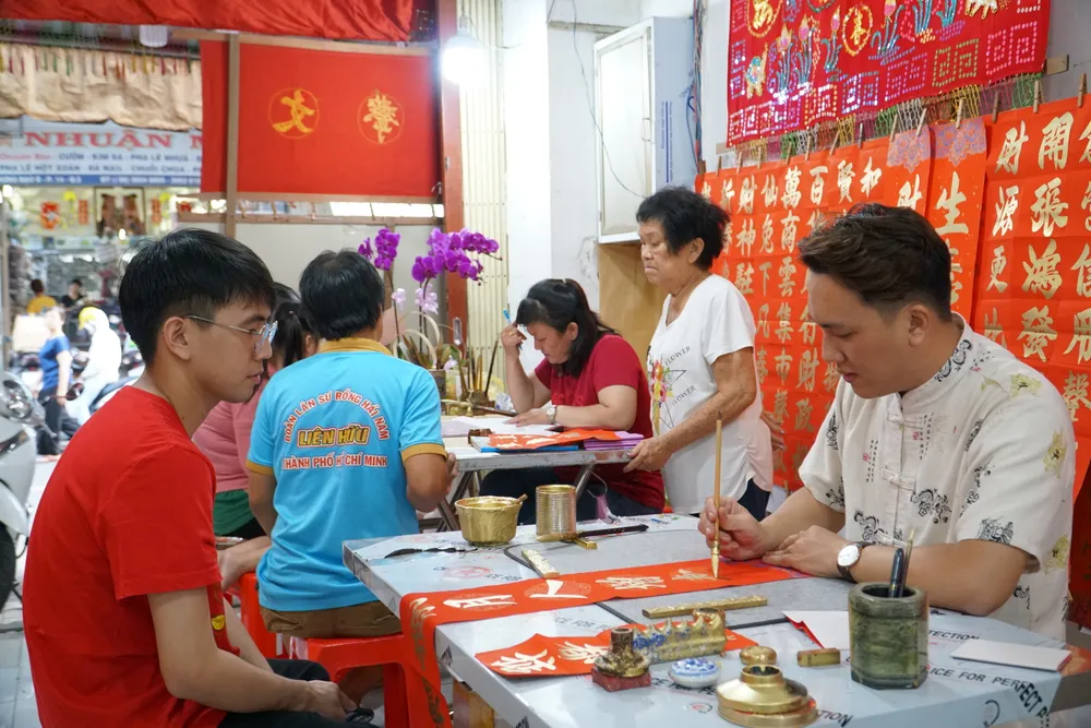 Mỗi năm vào đầu tháng chạp, các thành viên trong gia đình lại bày giấy mực, treo câu liễn đỏ rực rỡ góc phố khiến ai ngang qua cũng thấy lòng rộn ràng.