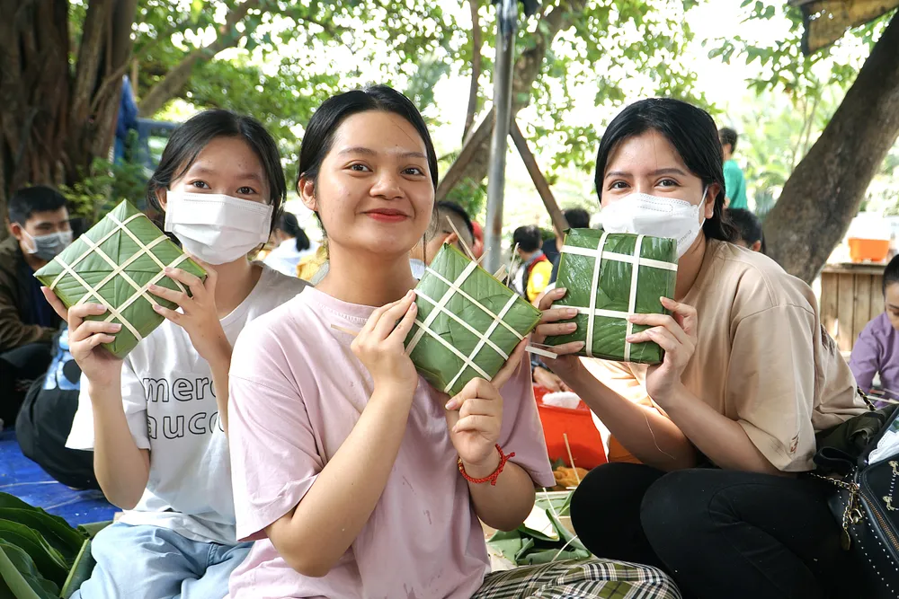 Cầm trên tay chiếc bánh chưng thứ 2 vừa gói xong, bạn Huỳnh Thị Minh Nguyệt (ở giữa, sinh viên trường ĐH Kinh Tế TP.HCM) vô cùng hào hứng vì đây là lần đầu tiên được tự tay gói chiếc bánh truyền thống. “ Có những cô chú không có điều kiện để gói bánh chưng nên khi trao tặng những chiếc bánh hy vọng họ sẽ có một cái tết ấm no hơn”, bạn Nguyệt chia sẻ.