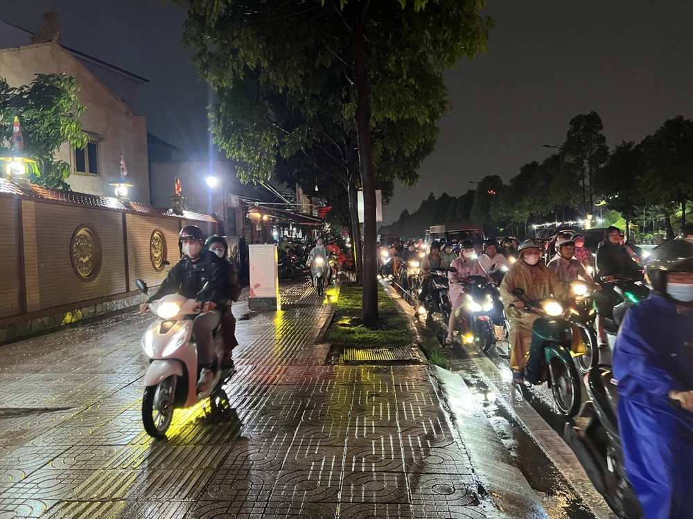 Một số người leo lên vỉa hè để di chuyển. Kẹt xe kéo dài trên đường Phạm Văn Đồng.