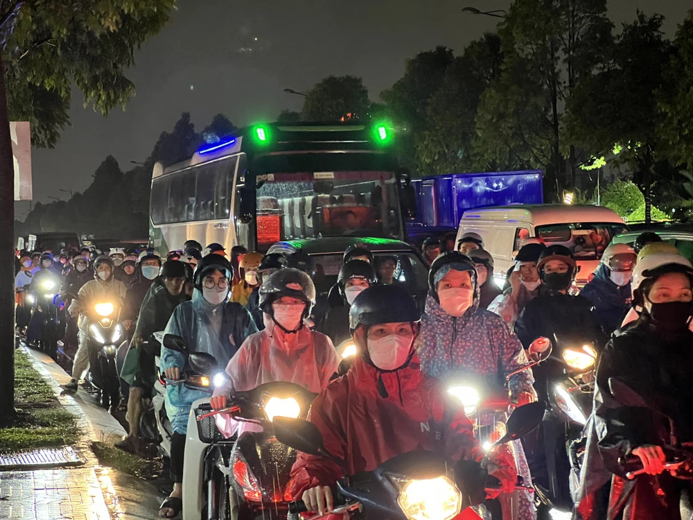 Người dân vất vả di chuyển về nhà. Kẹt xe kéo dài trên đường Phạm Văn Đồng.