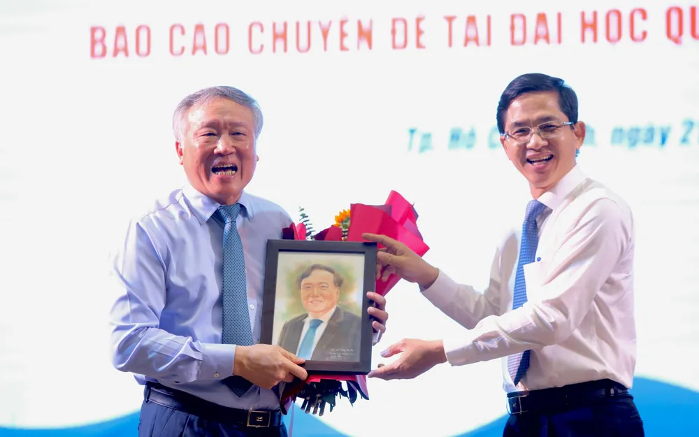 PGS.TS Hoàng Công Gia Khánh tặng quà lưu niệm cho Chánh án Nguyễn Hòa Bình. Ảnh: NGUYỆT NHI