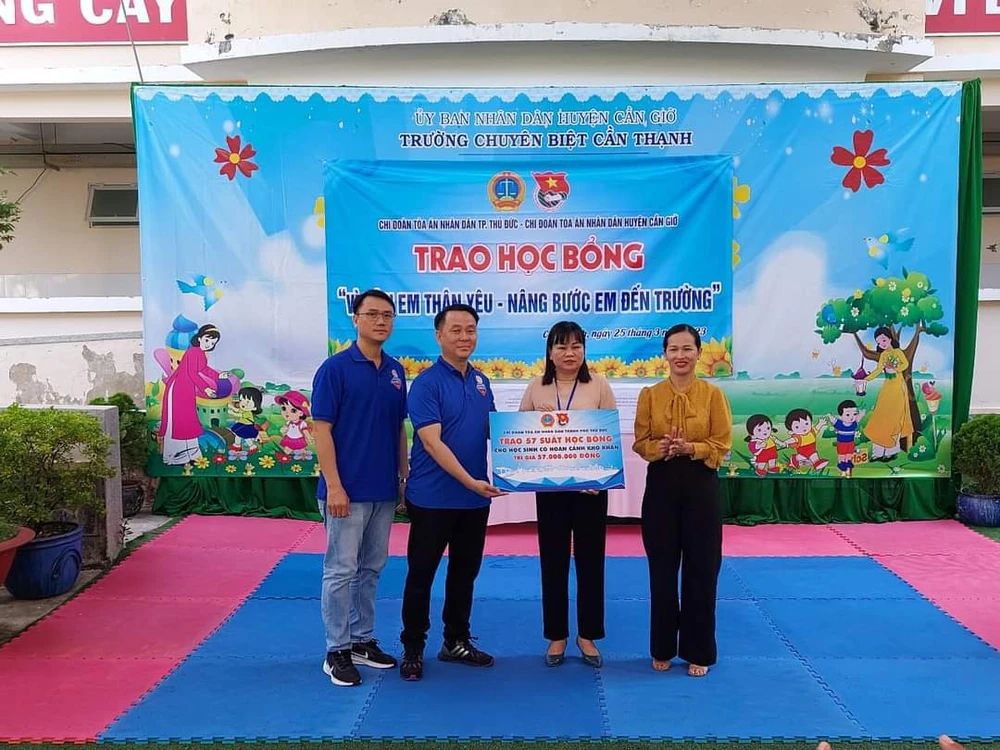 Chánh án TAND TP Thủ Đức Nguyễn Thành Vinh (thứ hai từ trái sang) trao 57 suất học bổng cho nhà trường và các em có hoàn cảnh khó khăn tại địa phương. Ảnh: THANH TRÍ/TAND TP THỦ ĐỨC