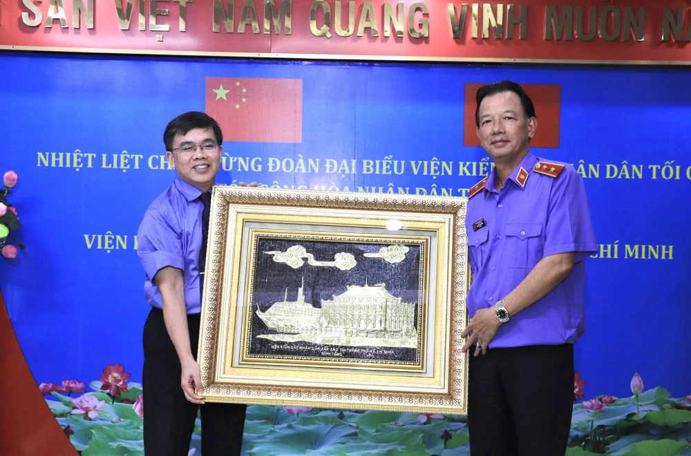 Ông Nguyễn Đình Trung, đại diện Viện Cấp cao 3 tặng quà cho Đoàn đại biểu Viện KSND Tối cao Trung Quốc. Ảnh: DI LINH