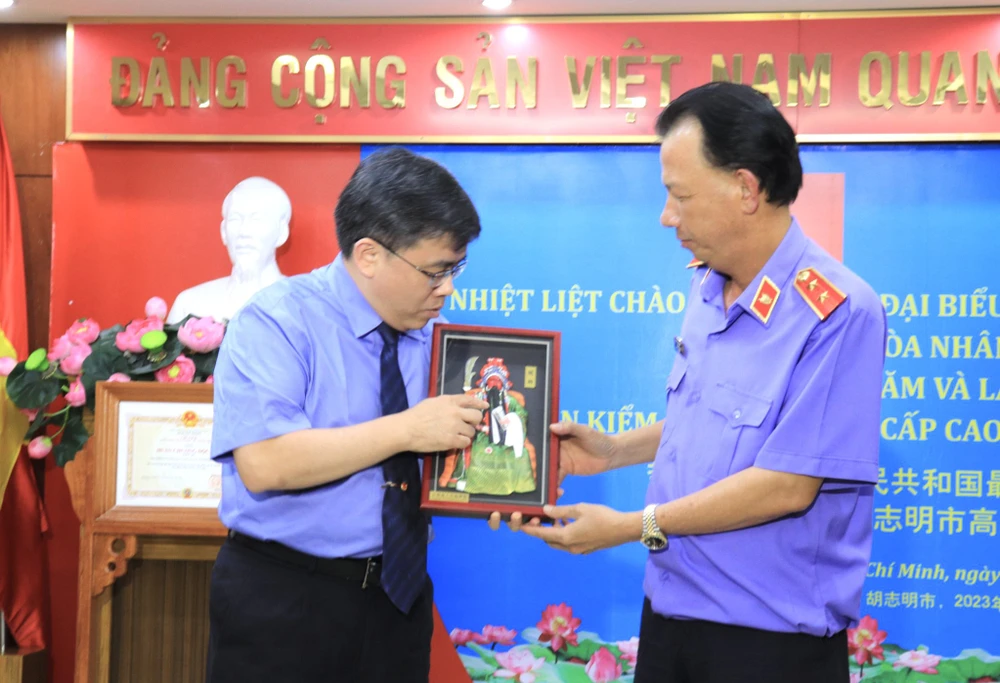 Ông Khưu Lợi Quân (bên trái) đại diện Đoàn đại biểu Viện KSND Tối cao Trung Quốc tặng quà lưu niệm cho Viện Cấp cao 3. Ảnh: DI LINH