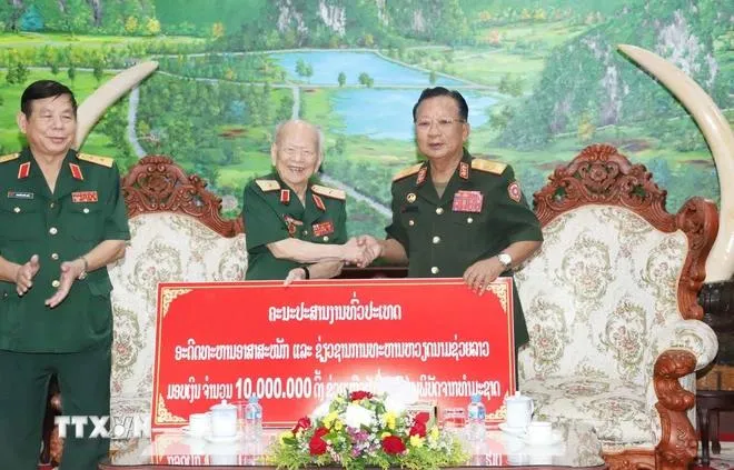 Đoàn trao tặng tiền ủng hộ người dân các vùng của Lào bị thiệt hại do mưa lũ gây ra. Ảnh: Xuân Tú/TTXVN tong-bi-thu-lao-quan-tinh-nguyen-4.webp
