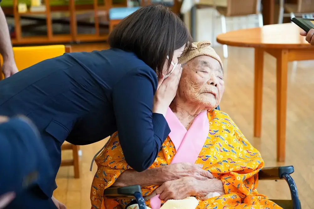 Yumi Yamamoto thì thầm vào tai Kikue Taira, em gái của cặp anh chị em lớn tuổi nhất thế giới. Ảnh: Nomoto Shunki Yumi Yamamoto thì thầm vào tai Kikue Taira, em gái của cặp anh chị em lớn tuổi nhất thế giới. Ảnh: Nomoto Shunki