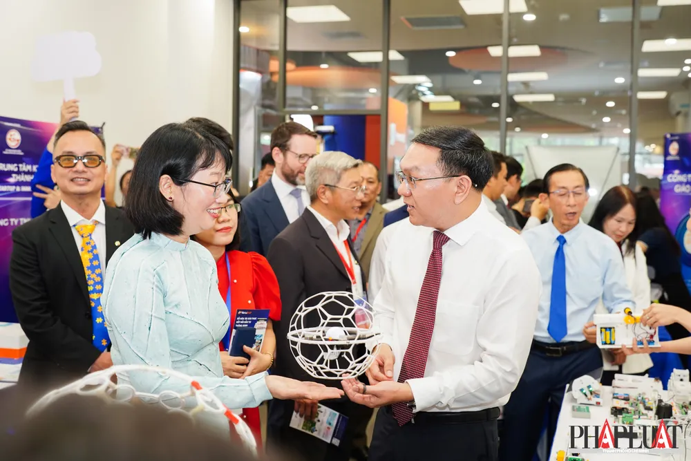 Bà Trần Thị Diệu Thúy, Phó Chủ tịch UBND TP.HCM (áo dài xanh) và ông Lâm Đình Thắng đi tham quan các gian hàng. Ảnh: MINH HOÀNG