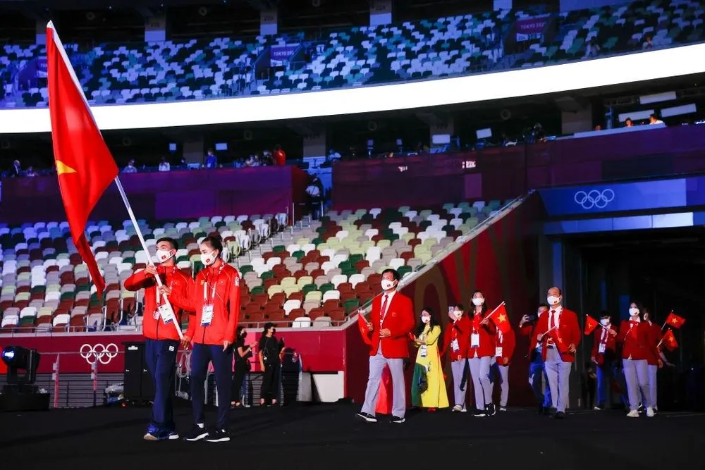 Kình ngư Huy Hoàng và Quách Thị Lan cầm cờ Việt Nam tại lễ khai mạc Olympic Tokyo 2020. ẢNH: GETTY