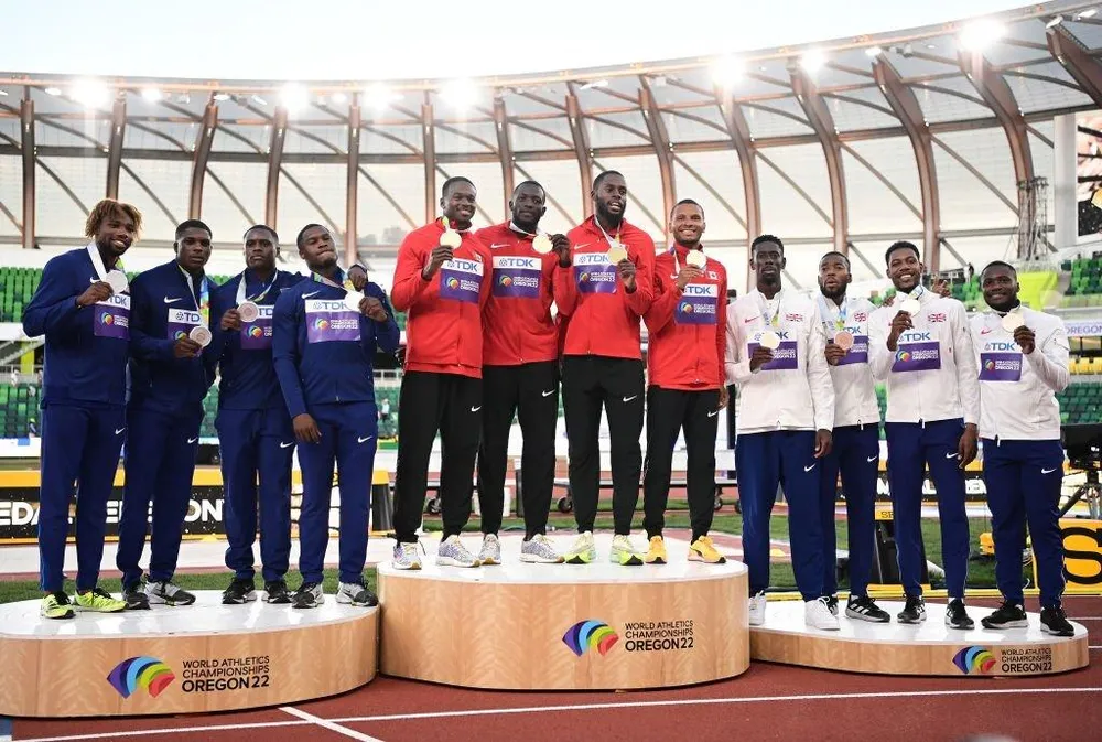 Đội tuyển điền kinh Mỹ (trái) trên bục nhận huy chương cự ly 4x100 m tiếp sức. Ảnh: GETTY Đội tuyển điền kinh Mỹ (trái) trên bục nhận huy chương cự ly 4x100 m tiếp sức. Ảnh: GETTY