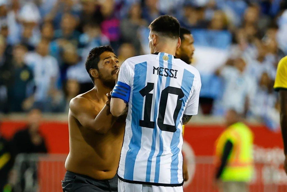 Một cổ động viên chạy vào sân xin chữ ký Messi. Ảnh: GETTY