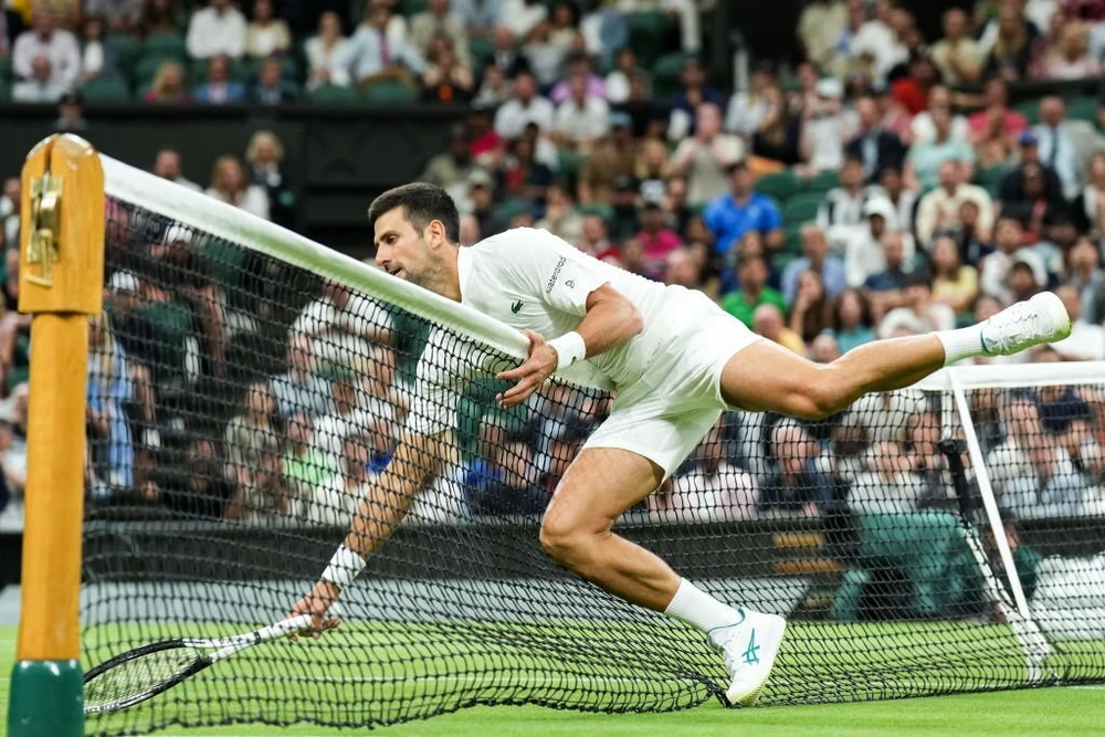Djokovic ngã nhào qua lưới sau một pha cứu bóng hỏng. Ảnh: GETTY