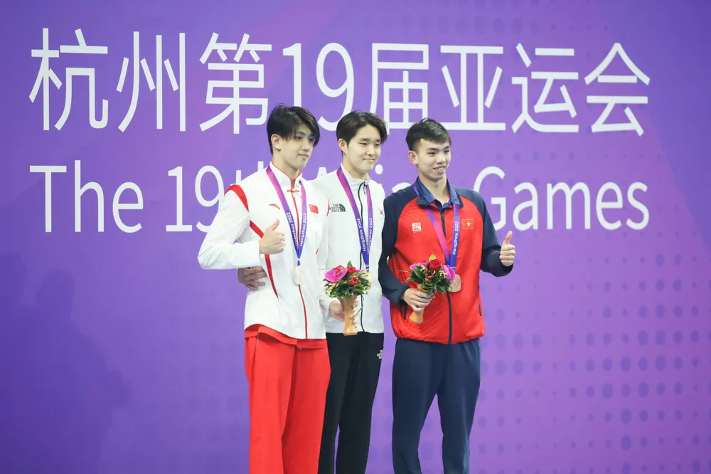 Huy Hoàng (phải) trên bục nhận HCĐ cùng vé dự Olympic 2024. kinh-ngu-nguyen-huy-hoang-vuot-chuan-a-2.jpg
