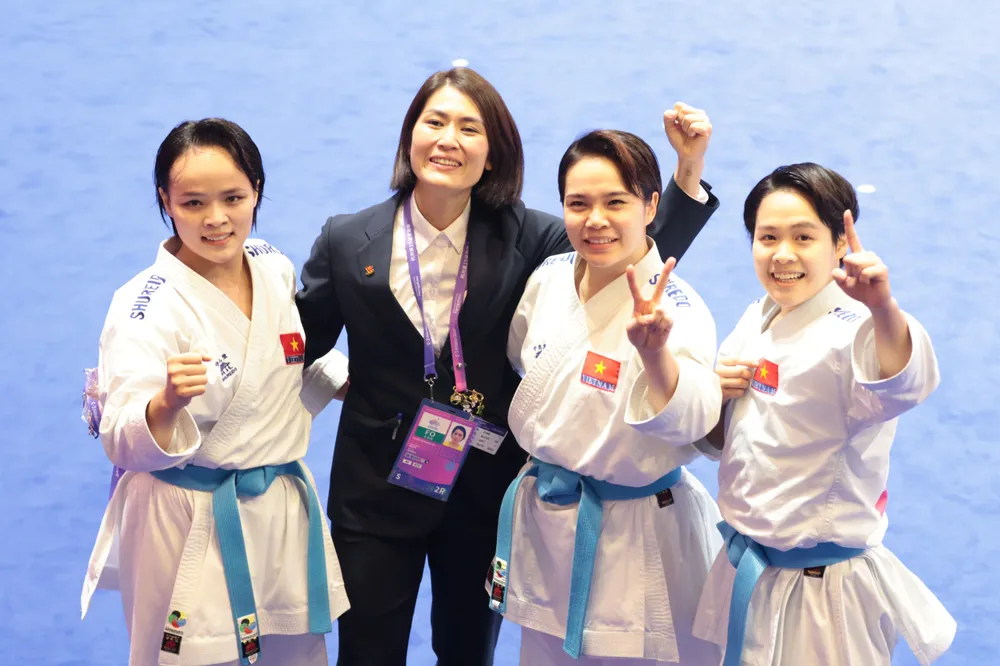 HLV Nguyễn Hoàng Ngân (áo đen) và các học trò ăn mừng chiếc HCV kata đồng đội nữ tại ASIAD 19. Ảnh: QUÝ LƯỢNG hcv-asiad-19-kata-nu-viet-nam.jpg