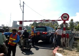 Xe biển đỏ tranh qua cầu tạm với xe máy ảnh 1