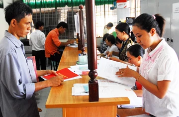 Người dân sẽ đỡ vất vả hơn khi giấy đỏ và giấy hồng được gộp lại thành một. Trong ảnh: Làm thủ tục giấy tờ nhà đất tại xã Bình Chánh (huyện Bình Chánh, TP.HCM). Ảnh: HTD