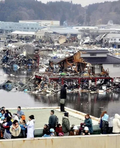 Người dân ở khu vực cảng Kesennuma nhìn đống đổ nát từ ngôi nhà của mình sau thảm họa. Người dân ở khu vực cảng Kesennuma nhìn đống đổ nát từ ngôi nhà của mình sau thảm họa.