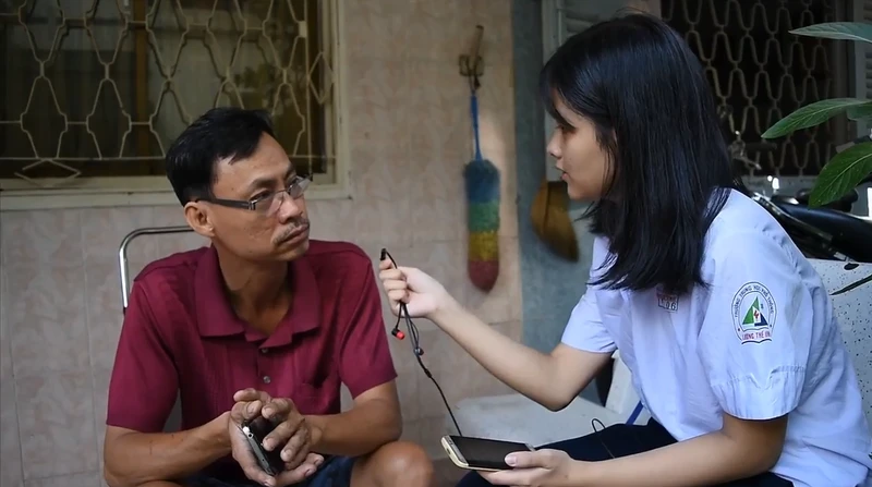 Một HS đang phỏng vấn người dân sống trong hẻm.