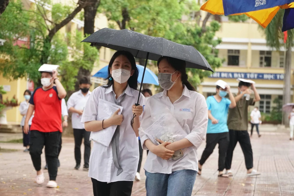 Nhiều thí sinh ở Hà Nội rời phòng thi trong cơn mưa. Ảnh: PHI HÙNG