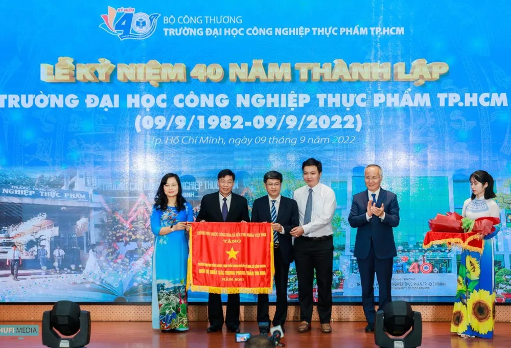 Thứ trưởng Bộ Công thương Trần Quốc Khánh trao Cờ thi đua của Chính phủ cho đại diện tập thể trường. Ảnh: PHẠM ANH