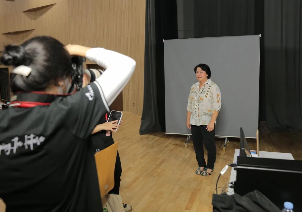 Bà Hương đang làm thủ tục chụp ảnh để làm thẻ sinh viên. Ảnh: MINH PHƯƠNG