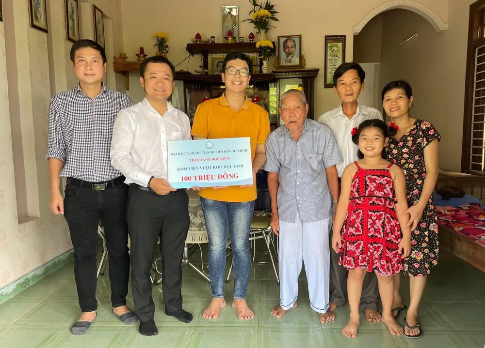 Đại diện Trường ĐH Y dược TP.HCM thăm gia đình và tặng học bổng cho em Lê Văn Hữu. Ảnh: TRƯƠNG ĐẠT