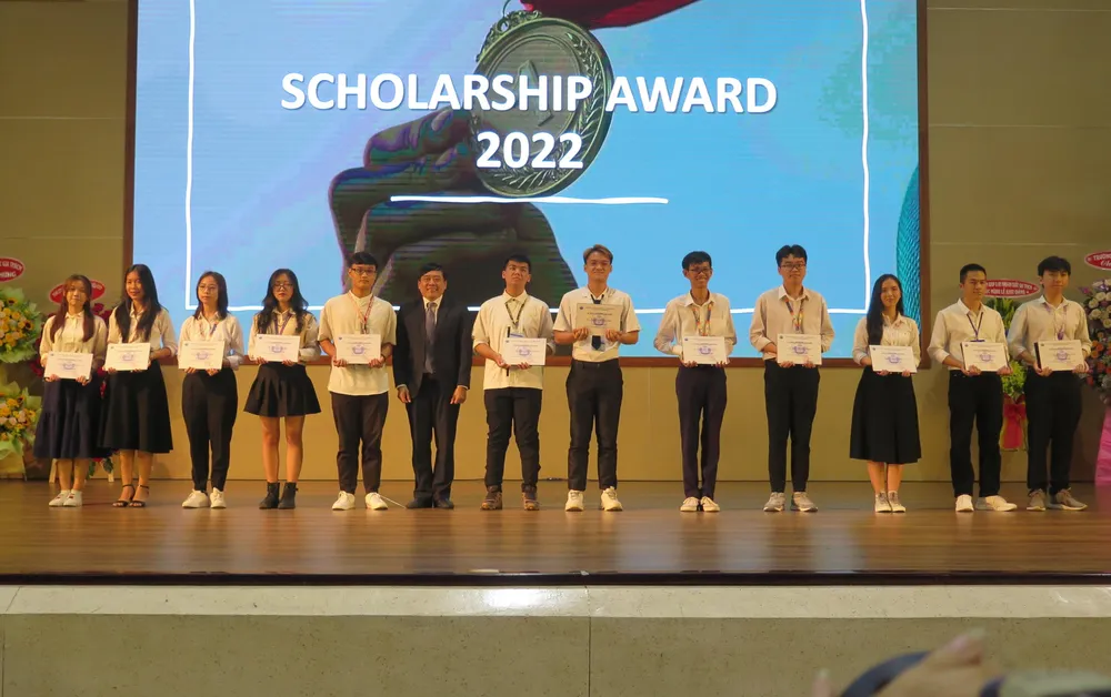 Hiệu trưởng Trần Tiến Khoa tặng học bổng toàn phần cho những tân sinh viên xuất sắc. Ảnh: P.ANH