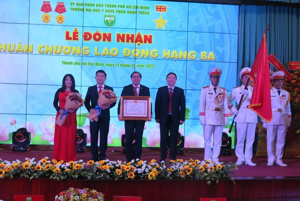 Ông Dương Anh Đức (ở giữa) trao Huân chương lao động hạng ba cho tập thể Trường ĐH Y khoa Phạm Ngọc Thạch. Ảnh: PA